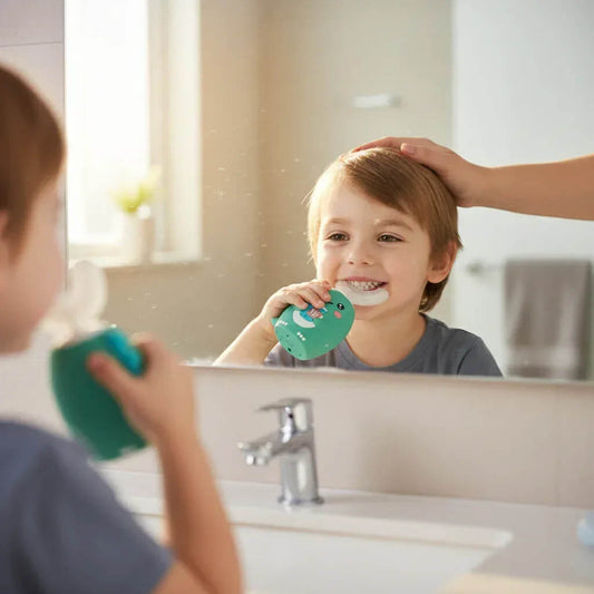 Child brushing teeth with a green toothbrush in front of a mirror, with an adult's hand on their head.