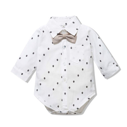 White baby bodysuit with black polka dots and a beige bow tie on a white background