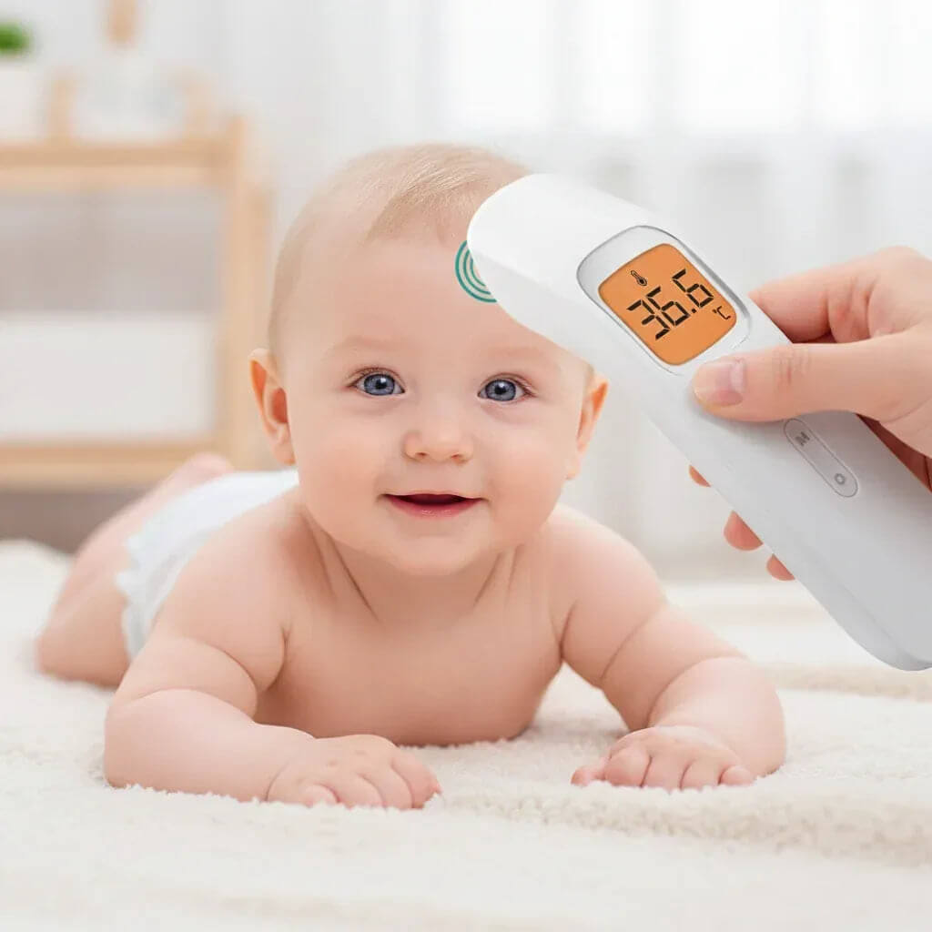 Baby lying on a white blanket with a digital thermometer being held above its head.